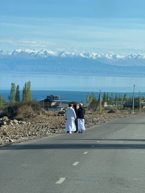 Group gathers roadside in Çolpon-Ata, some in white robes