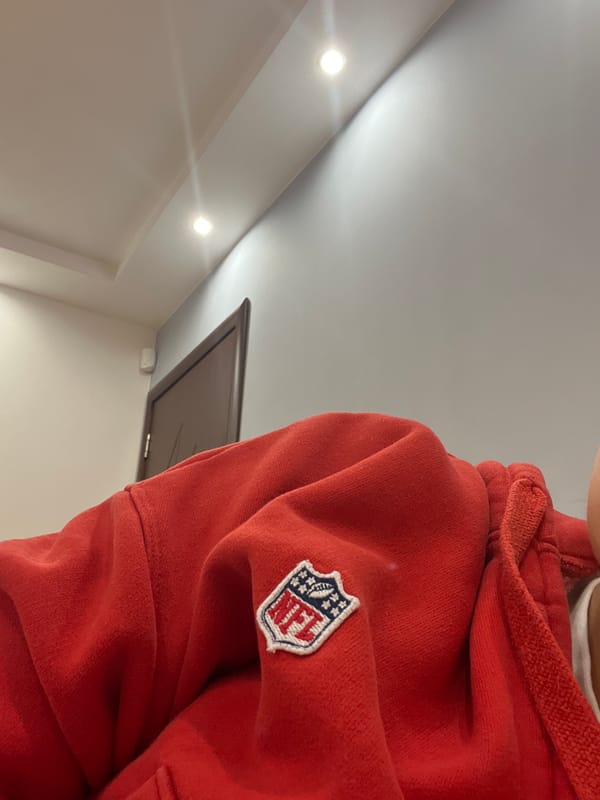 Person in NFL sweatshirt photographed indoors in Pernik