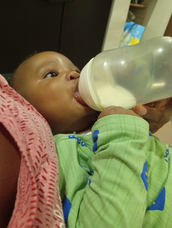 Bottle feeding moment at home in Abuja