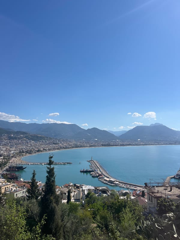 Cruise ship docks at Alanya harbor amid coastal views