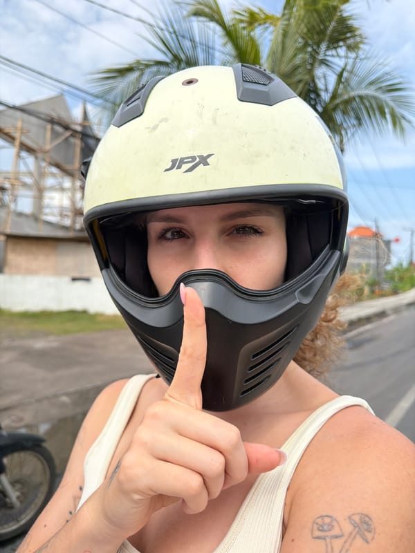 Woman in JPX helmet makes playful gestures during motorcycle ride