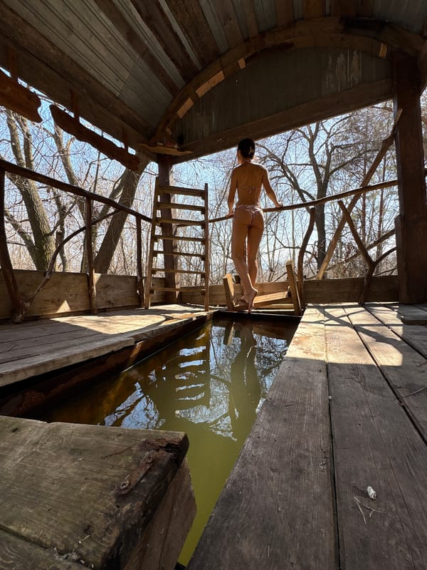 Woman stands on wooden platform over water in Ulyanovsk