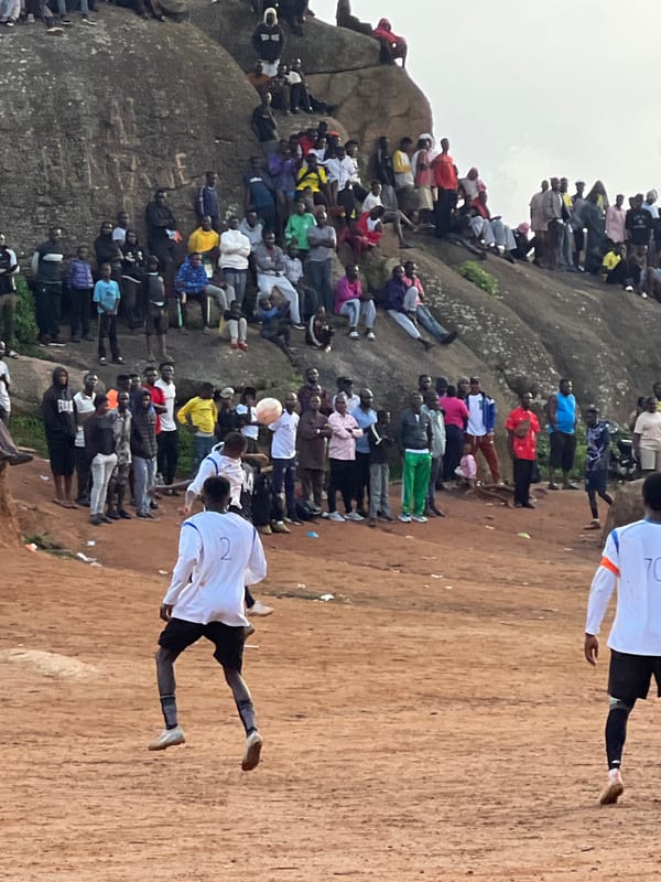Pickup soccer game draws a crowd on rocky terrain in Jos