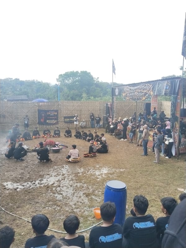 Traditional masked performance draws crowds in muddy Gentungan field