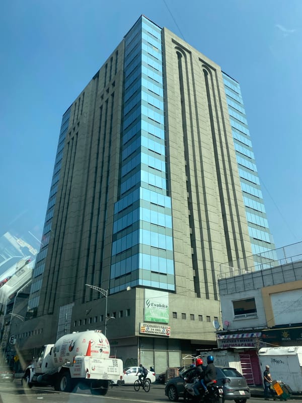 Tall glass-concrete building documented under clear skies