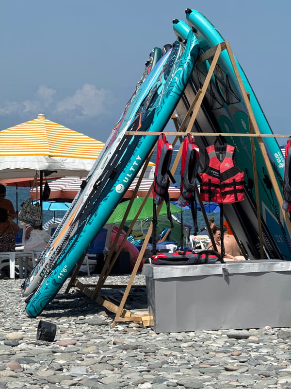 Beach gear, juice stands, and palm-lined walkways on a busy morning