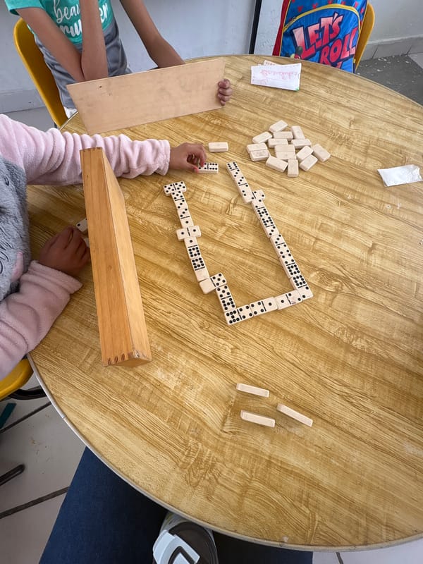 Children play dominoes at table in Puebla