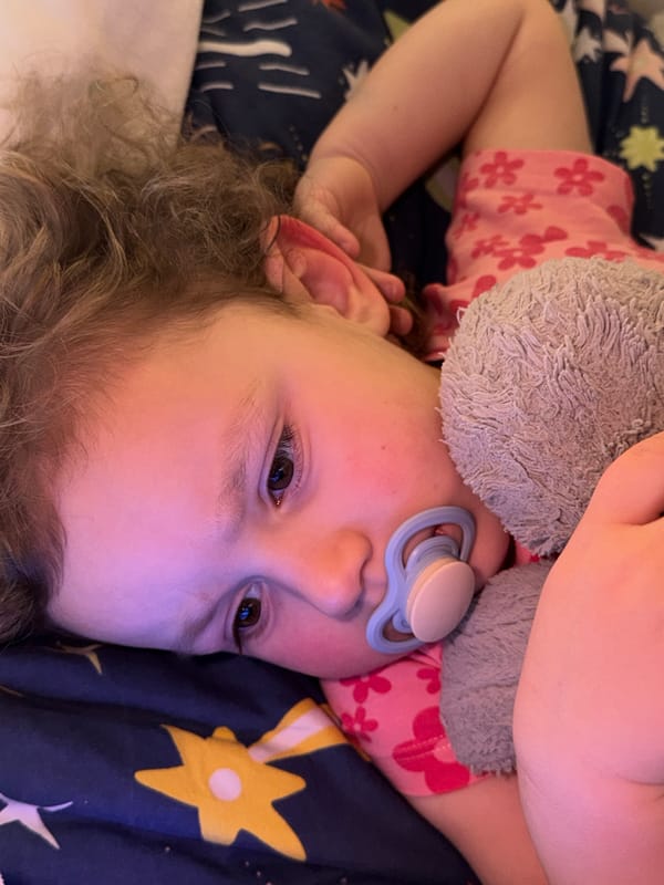Child rests on star-patterned bed in German home