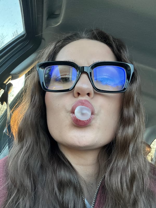 Woman blows bubble gum in car in Garevaya
