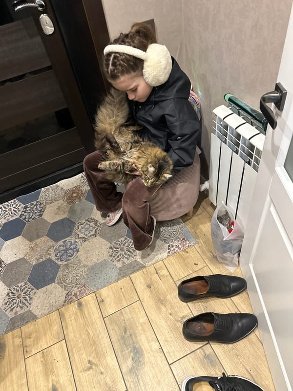 Person in black jacket interacts with pets indoors