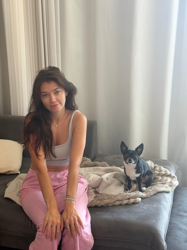Woman relaxes with small dog on couch in Tel Aviv