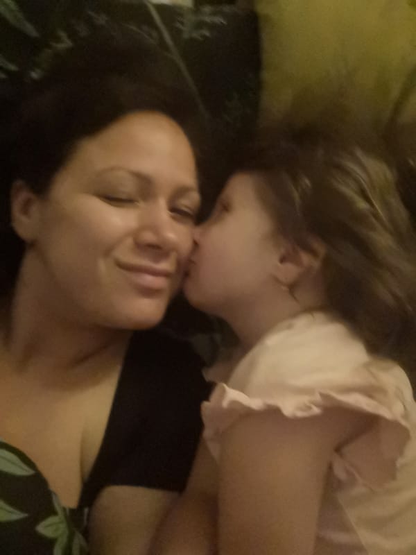 Mother and daughter share tender kiss moment