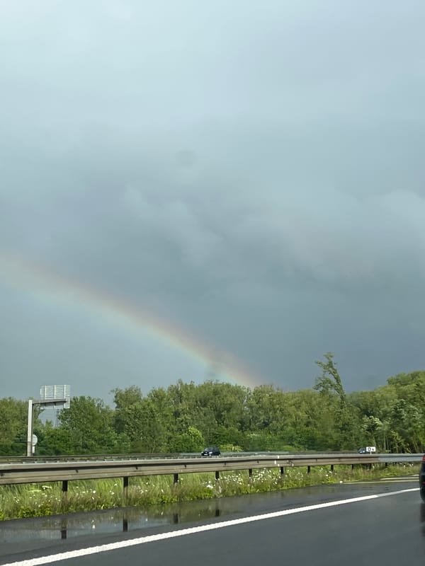 Rainbow appears over wet highway near Richemont, France