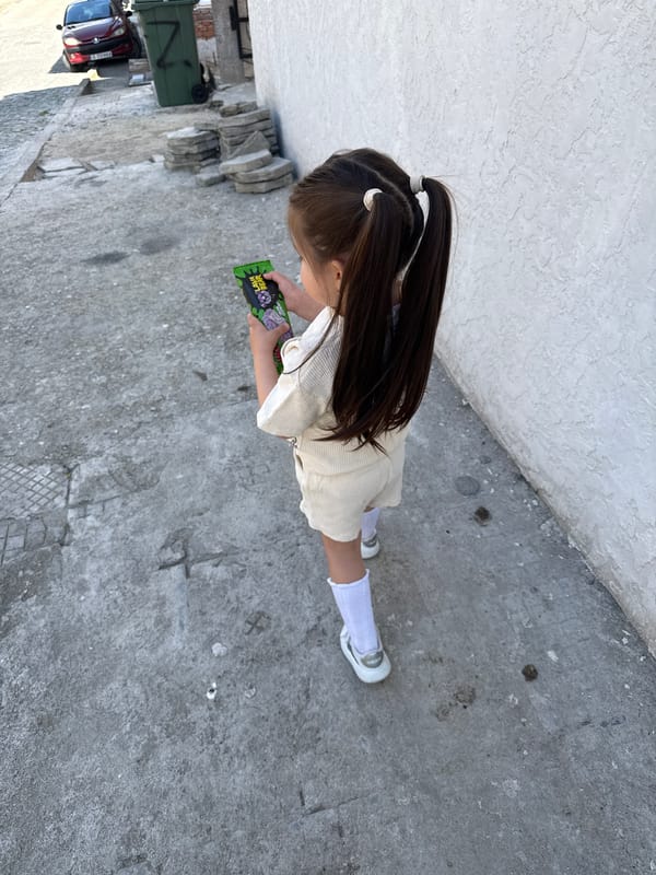 Girl in pigtails stands on sidewalk in Sandanski