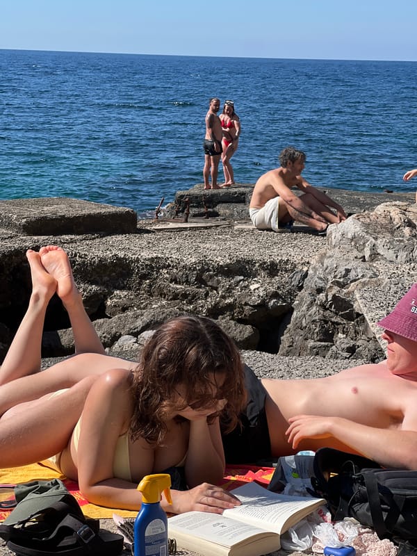 Sunny afternoon on Palermo's rocky coast with windsurfers