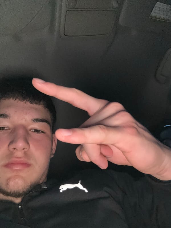 Person makes peace sign while resting in Honda car