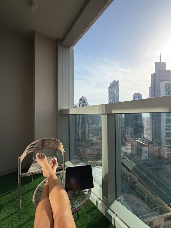 Person relaxes on high-rise balcony in Dubai Business Bay