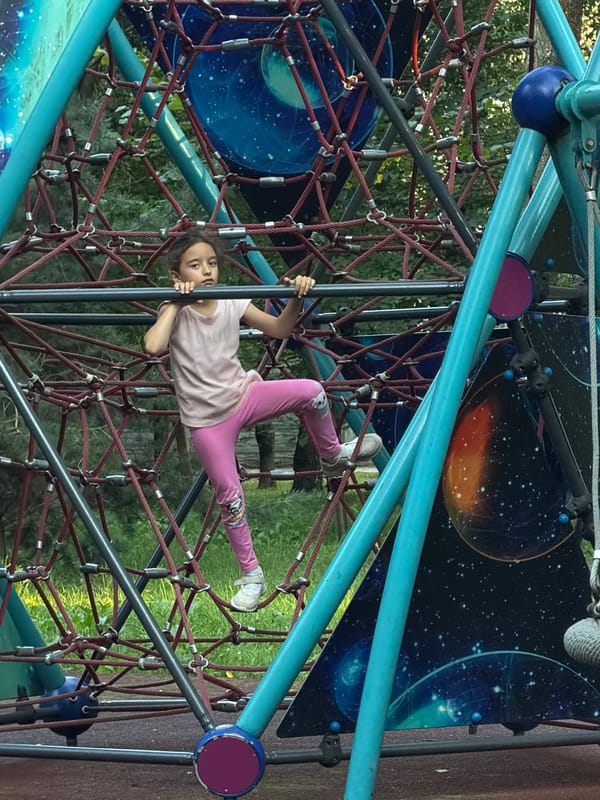 Kids climbing and skating on a playground structure.