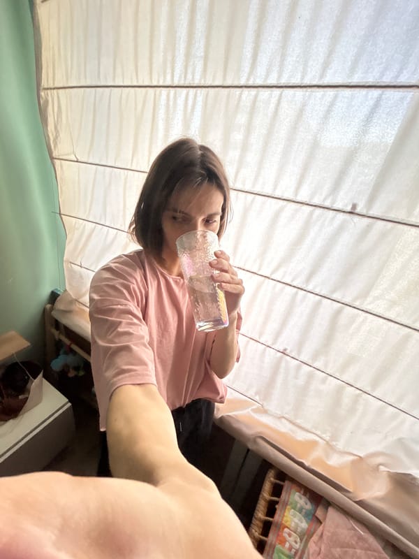 Woman drinks from glass in tent-like space, Moscow