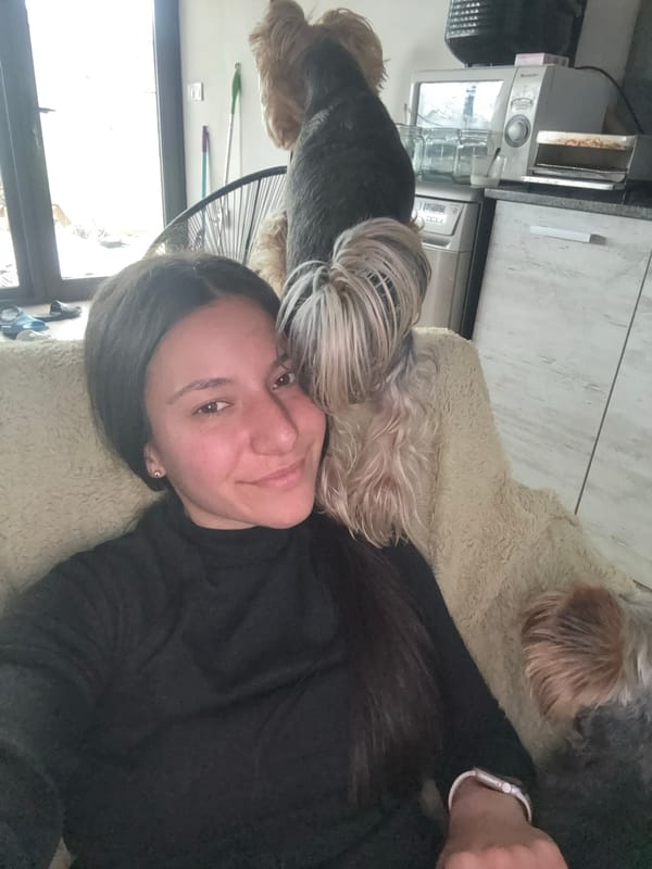 Woman relaxes with Yorkshire Terriers on couch in Bulgaria