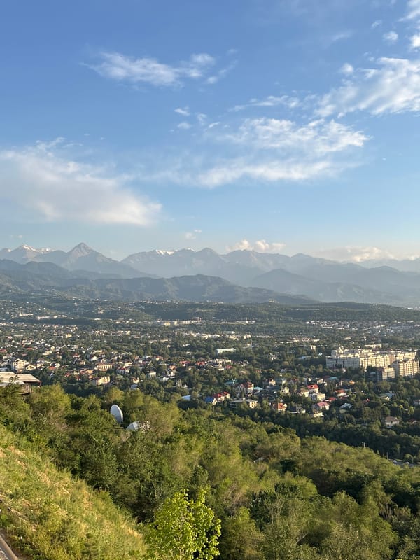 Almaty skyline stretches wide beneath mountain backdrop from Kok Tobe
