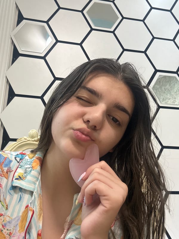 Woman poses with pink heart-shaped object in pajamas