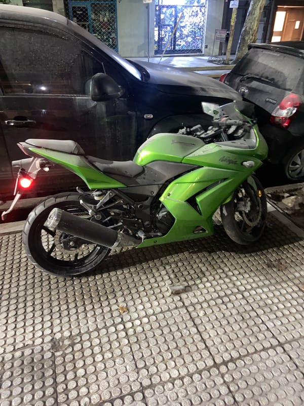 Motorcycle down on Buenos Aires walkway, entangled with vehicle
