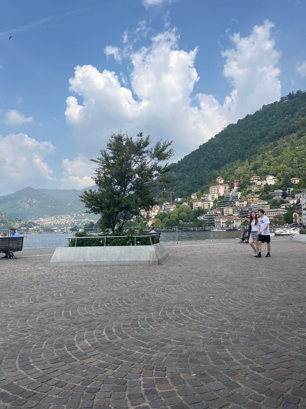 Couple enjoys lakeside moment on Como's cobblestone promenade