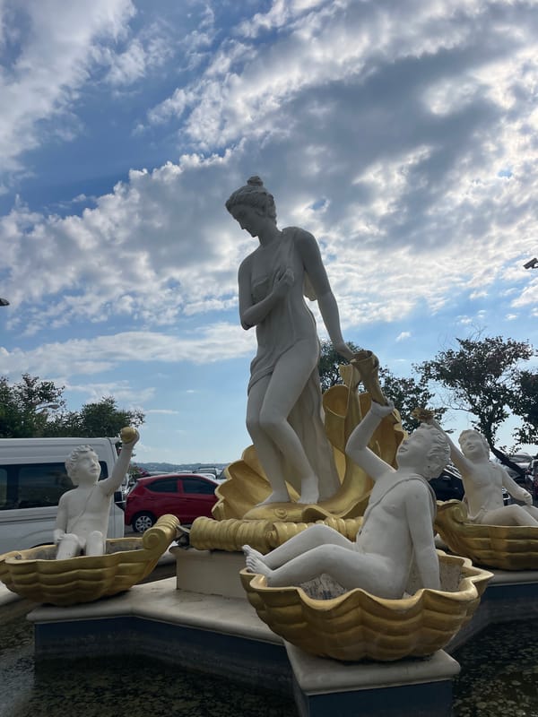 Manado's coastal promenade and shoreline sculpture on a clear morning