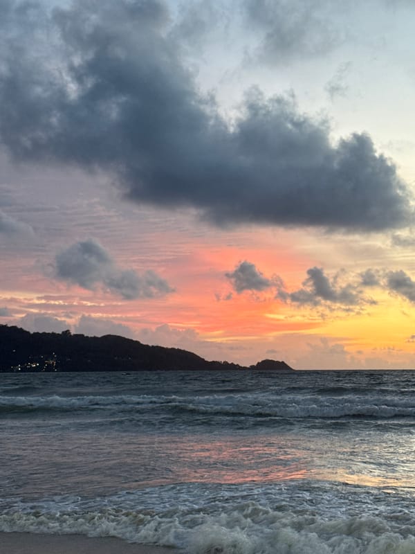 Patong Beach at dusk, jet skis and pink skies