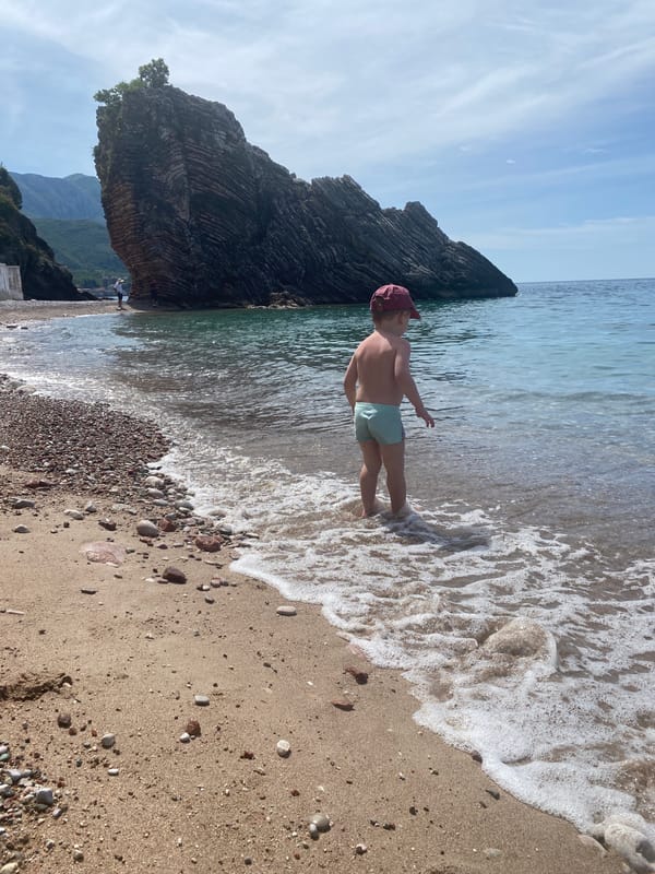 Child plays with toys on Montenegro beach morning