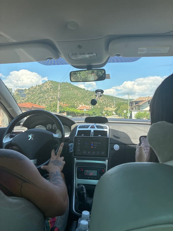 On the road through Jeleznitsa, phone out, window ahead.
