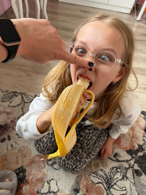 Girl eats banana in soccer sweatshirt, Dreiliņi Latvia