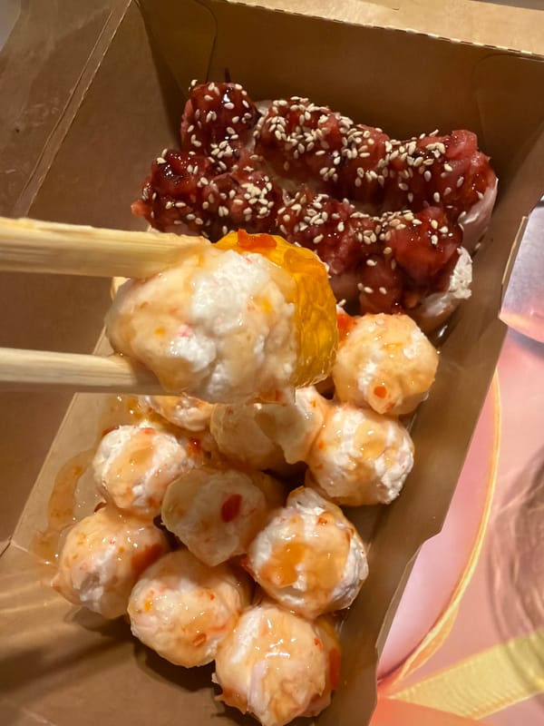 Person eats takeout meal with chopsticks from compartmented container