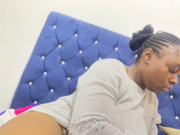 Woman observed sitting on blue couch in Abuja indoor setting