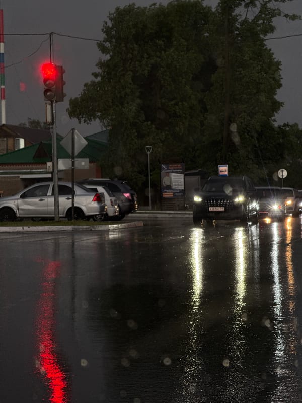 Rainy evening traffic observed at railroad crossing in Agryz, Russia