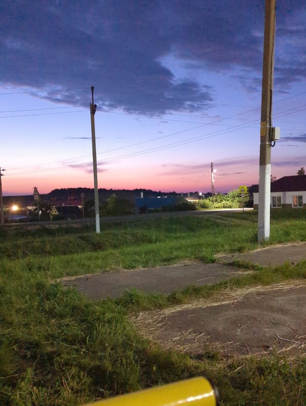 Dark purple clouds roll in at dusk, sky shifting pink