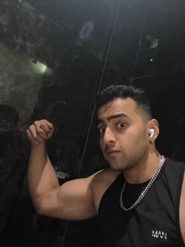 Man poses for photos in dimly lit Kolkata indoor setting