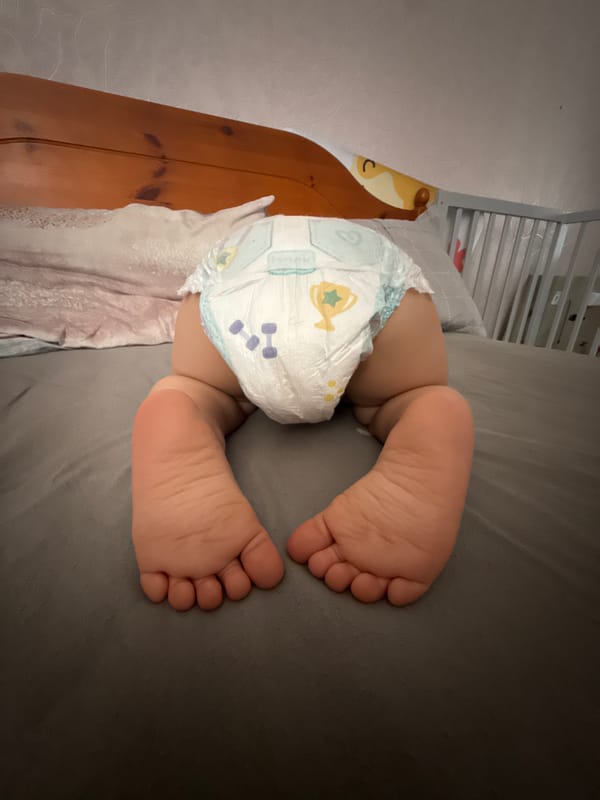 Baby on all fours on a bed at home in Liepāja
