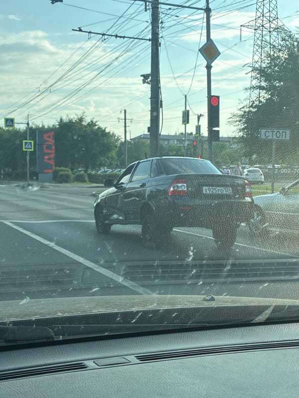 Black Lada at Russian intersection with traffic signals