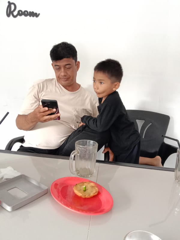 Man and child share late-night meal at Lhokseumawe cafe