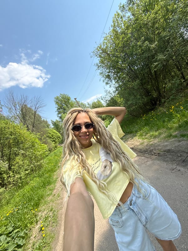 Woman poses for selfie on woodland path in Rusanovo