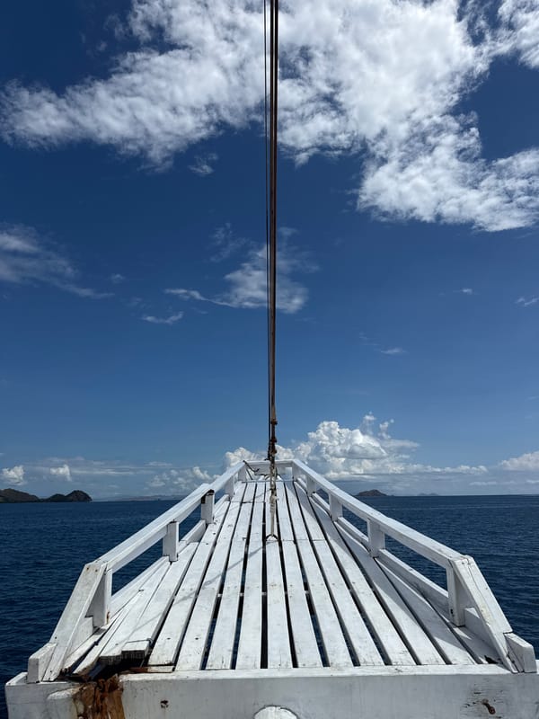 Men operate equipment aboard traditional boat near Labuan Bajo