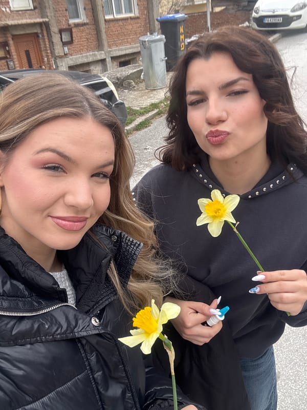 Two women pose with daffodils for selfie in Velingrad