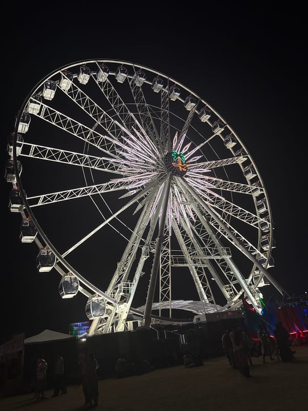 Illuminated Ferris wheel operates at night in Indio