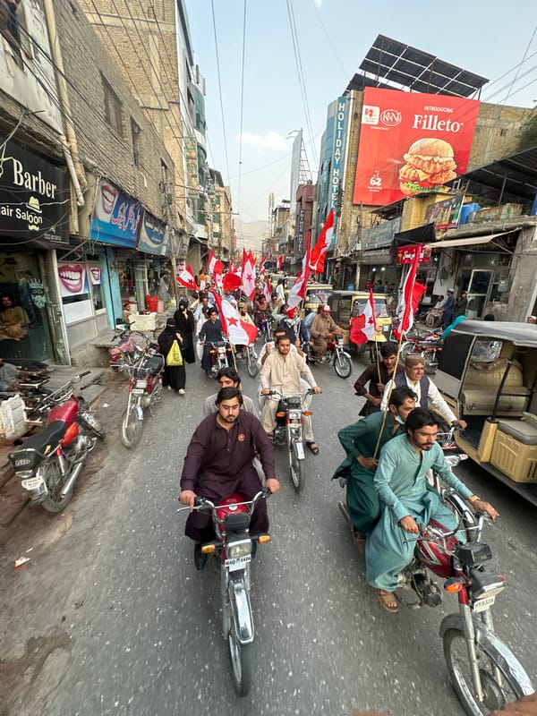 Flag-bearing procession rolls through Quetta's busy commercial streets