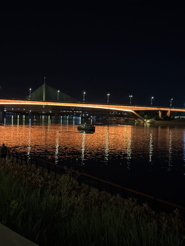 Nighttime urban lights captured across bridge and buildings