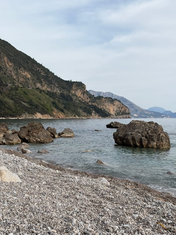 Couple enjoys fruit picnic on Montenegro pebble beach