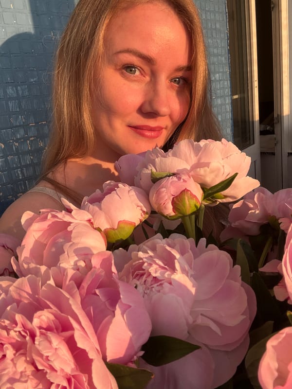 Woman with pink peonies photographed during Chaikovsky sunset session