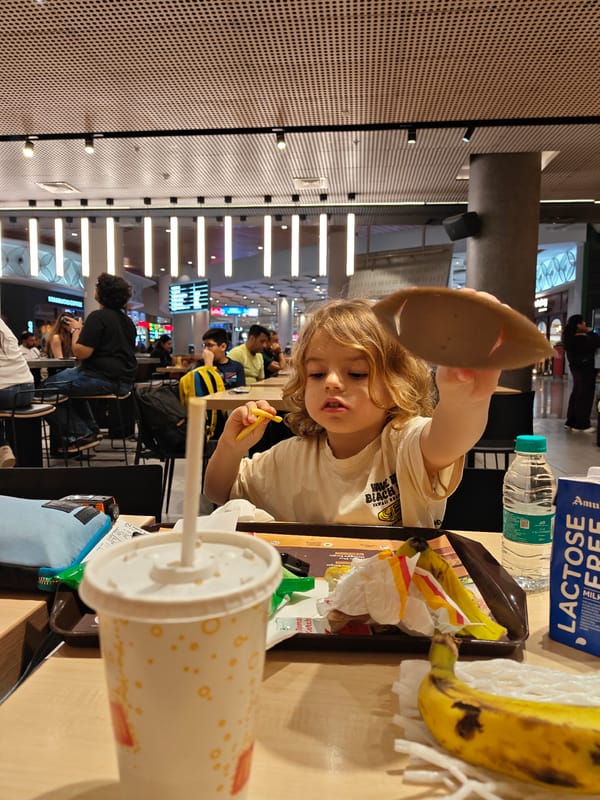 Child holds cardboard lid at Mumbai food court